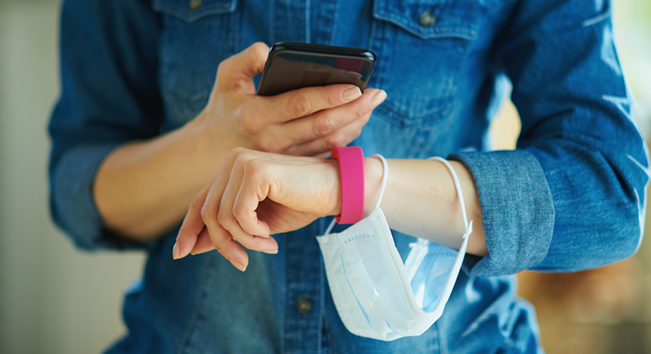 Woman holding smartphone and face-mask